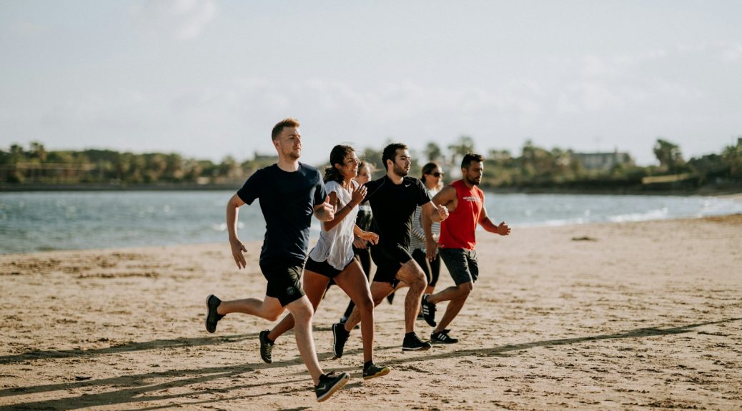 A group of people running together along a beach
